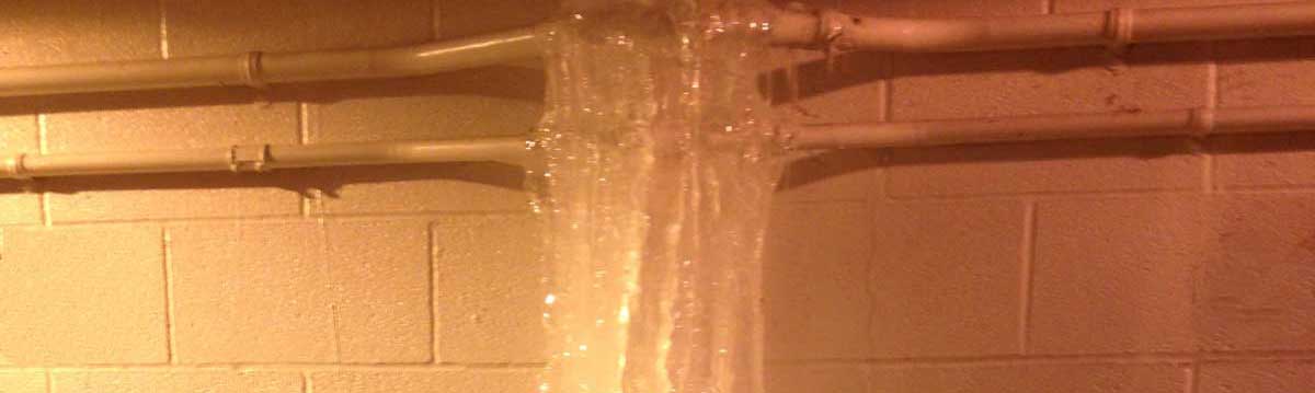 A frozen basement pipe causes damage by expanding and cracking or bursting, leading to significant water leaks that can ruin drywall, insulation, floors, and stored items